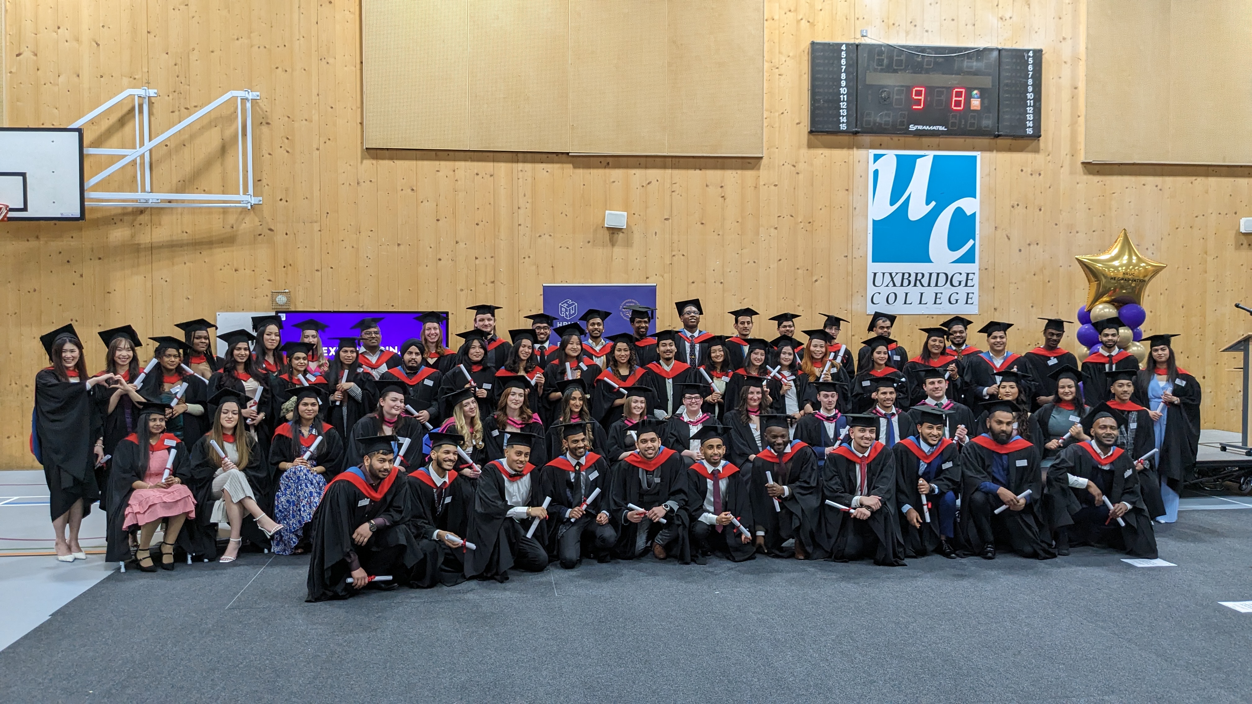 Group shot of all the graduates looking into the camera, smiling.