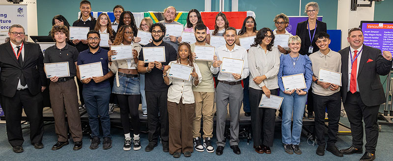Harrow, Richmond and Uxbridge Colleges (HRUC) students who took part in the Turing Scheme Overseas Placements  in a group holding up their certificates and smiling. They are joined by Jo Withers, Liam Plumridge and Tim Wells.