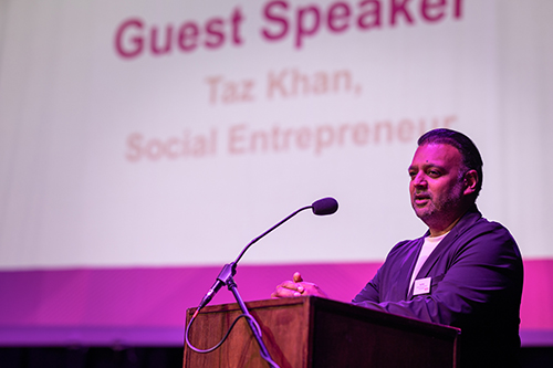 Special guest speaker, Taz Khan, founder of London’s Community Kitchen, talking at the lectern on stage at the 2025 Harrow College Student Awards evening. 