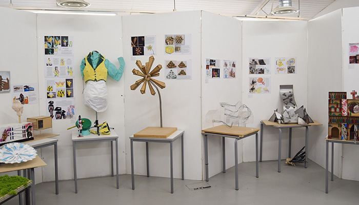 Various displays of Harrow College Art and Design students work for the end-of-year showcase. There is work on walls and tables of fashion, models, 3D design and more.